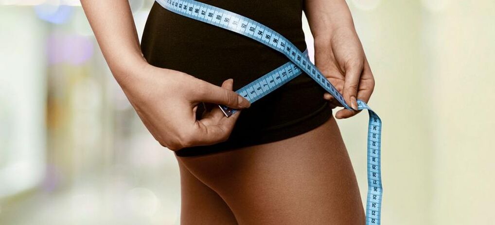 En kvinne registrerer resultatene av effektivt vekttap